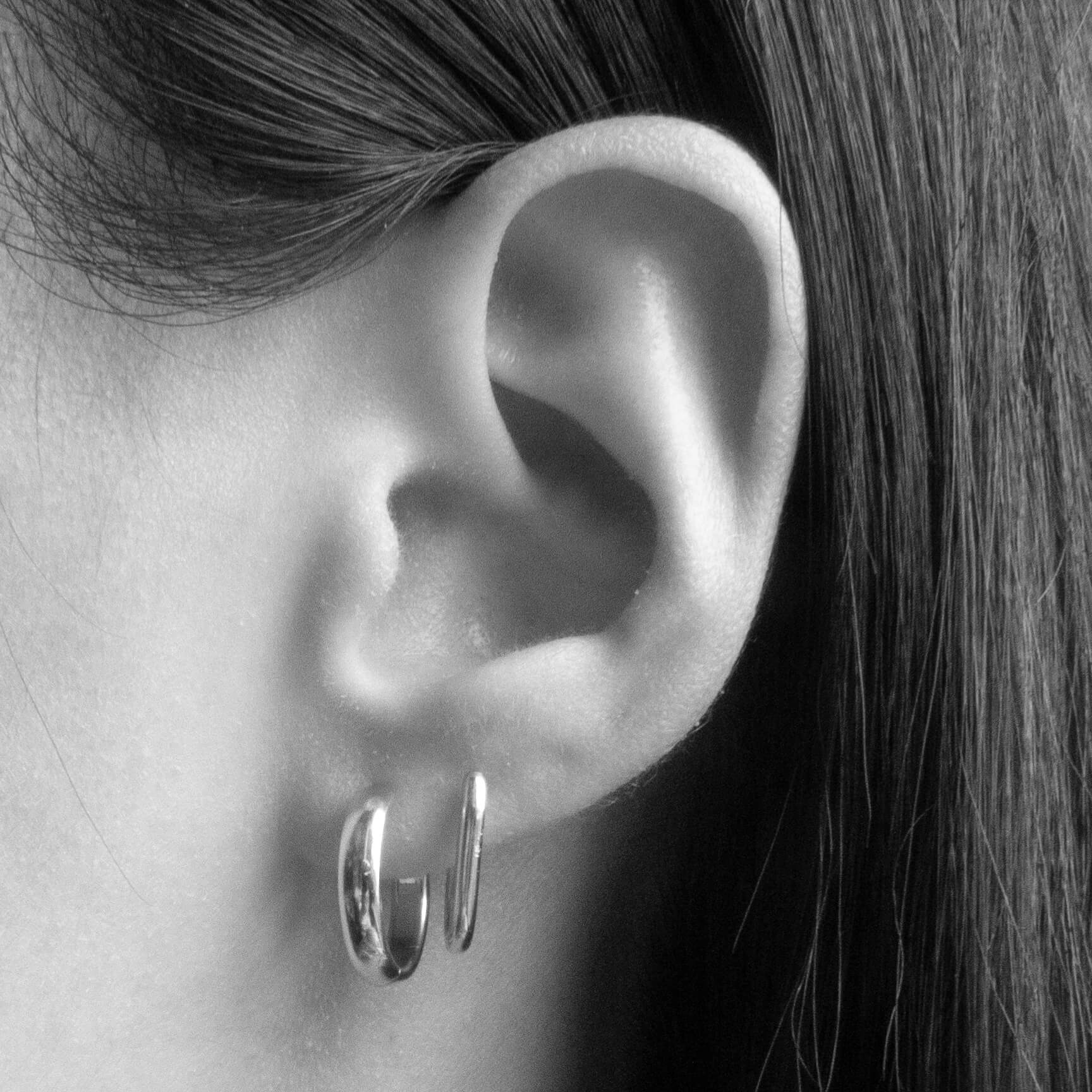 Baby Halo Oval Hoop Earrings in Titanium (Silver) on model